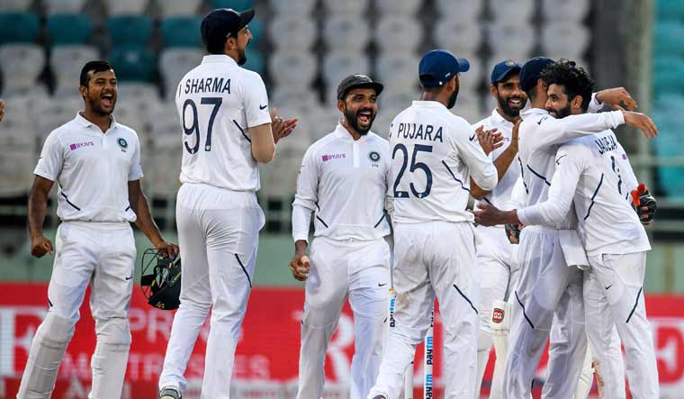 Indian players congratulate Ravindra Jadeja (R) after taking the wicket of South Africa's Dean Elgar | AFP