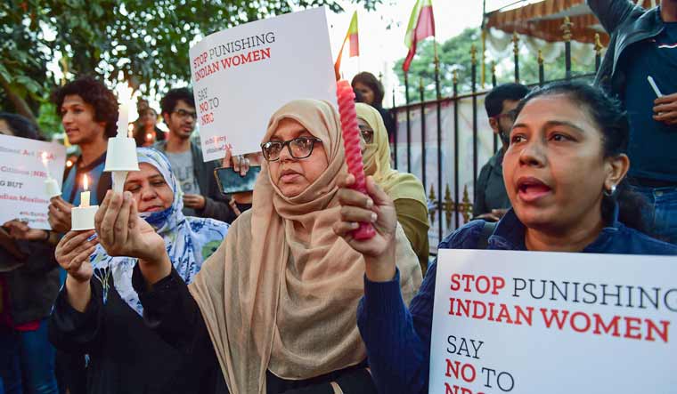 Protestors hold placards as they raise slogans during an anti-Citizenship Act candle light protest, in Bengaluru | PTI