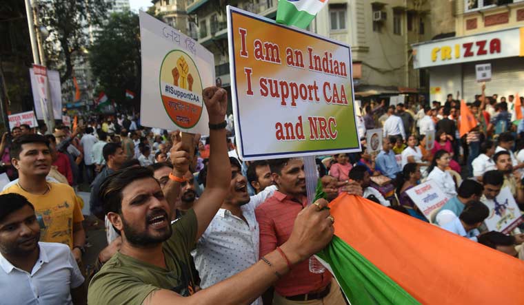Protesters hold placards and flags during a rally in support of new citizenship law in Mumbai | AFP