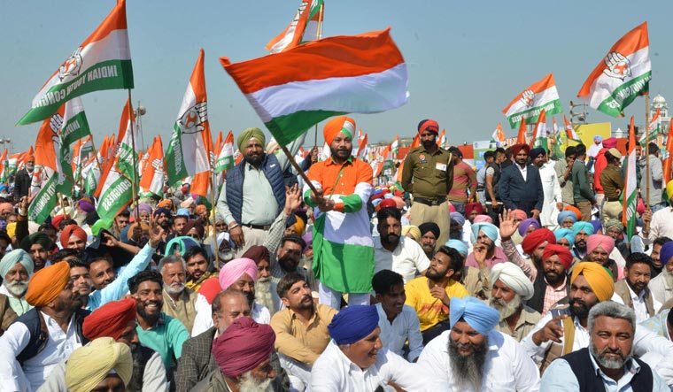Congress party supporters hold party flags at a rally in Killi Chahlan village near Moga on March 7 | AFP
