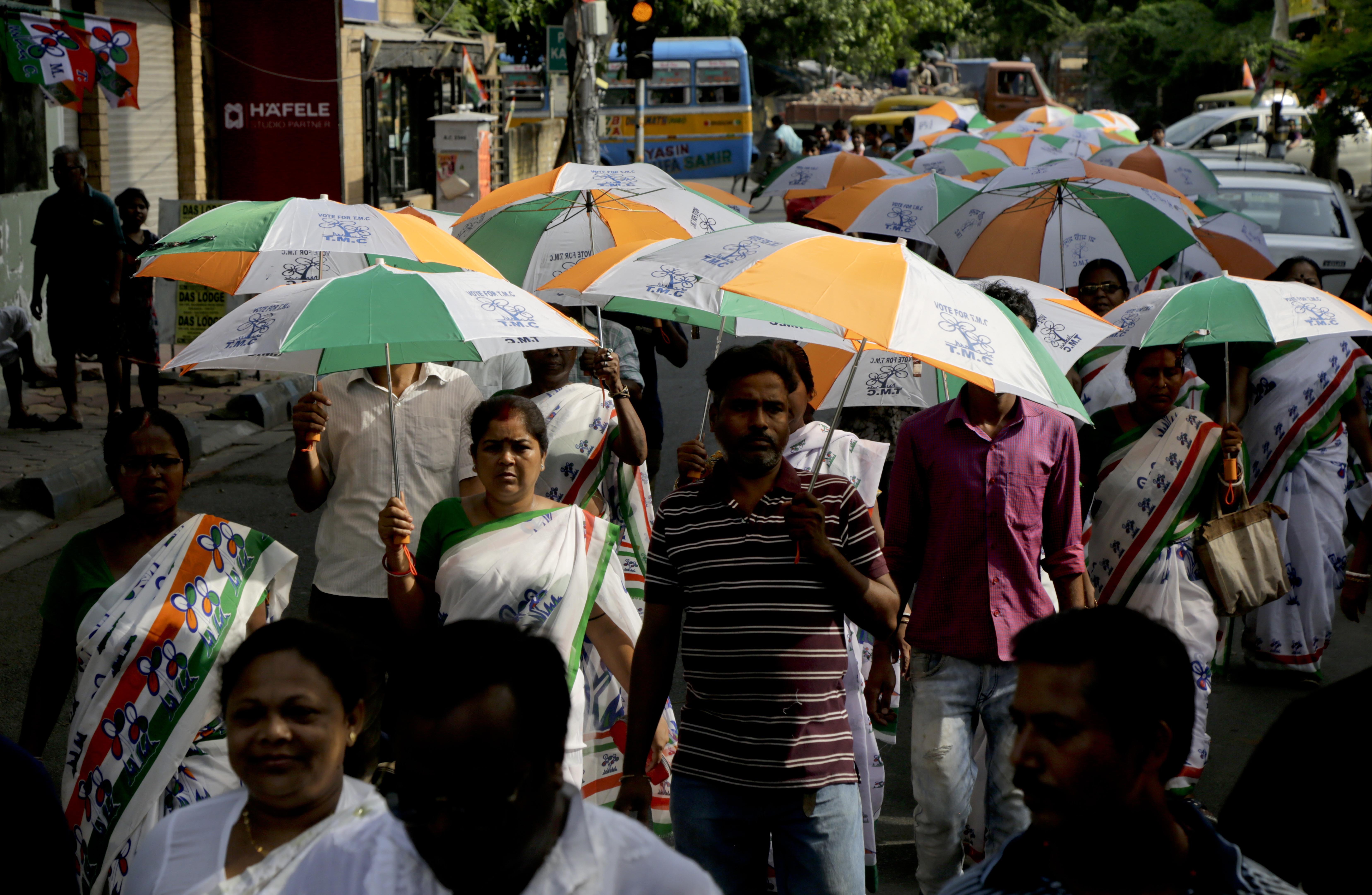 Supporters of Trinamool Congress party holding umbrellas with party symbol walk in an election campaign rally in Kolkata | AP