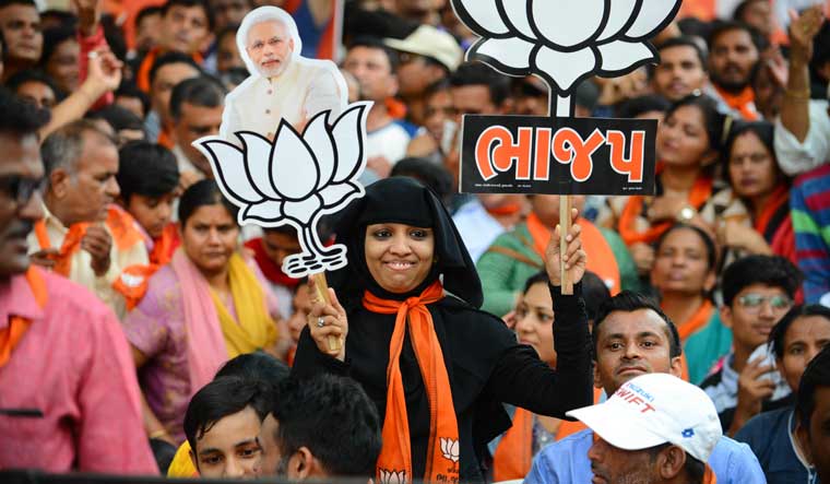 A Muslim supporter of the BJP holds a cutout of Prime Minister Narendra Modi as she attends a rally in Ahmedabad on May 26 | AFP