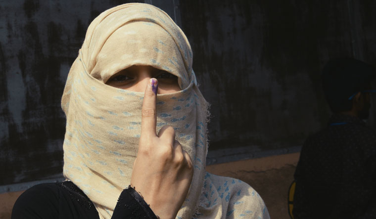 A woman shows her finger marked with indelible ink at a polling station in Howrah, West Bengal | Salil Bera