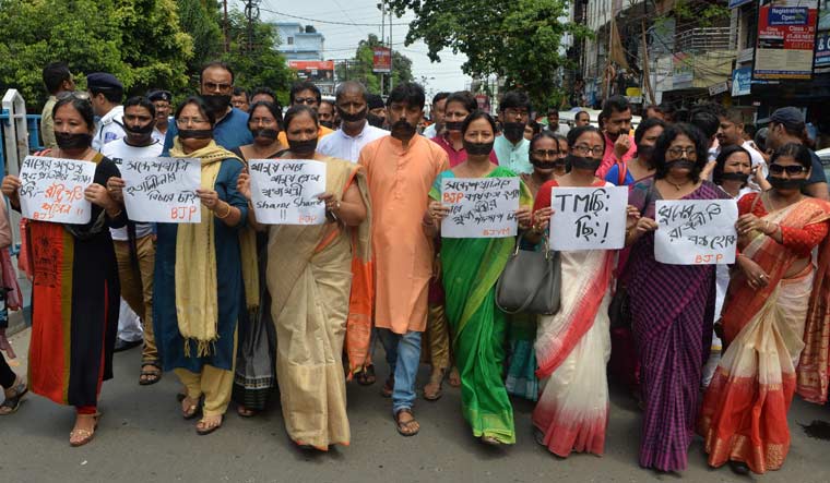BJP supporters hold placards as they observe 'Black day' during a silent protest rally against the recent killings at Sandeshkhali in West Bengal | AFP
