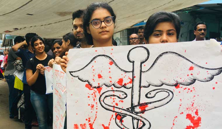 Doctors hold placards during their strike in protest against an attack on an intern doctor, in Kolkata | Salil Bera