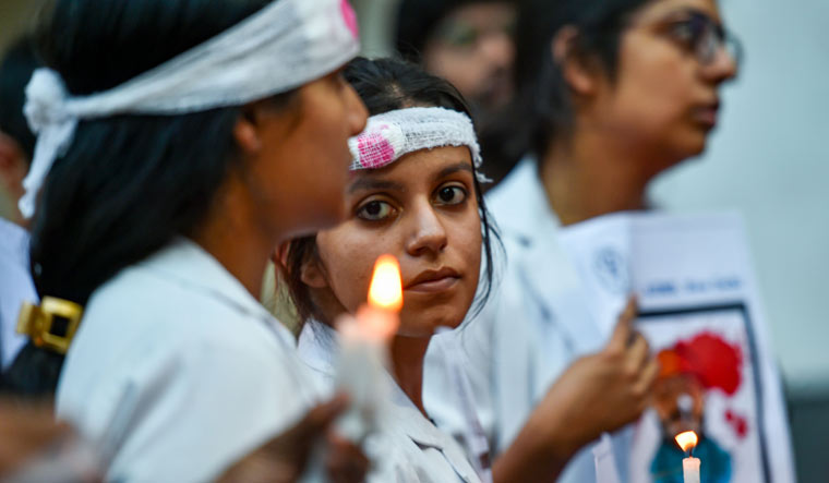 Doctors wear bandages on their heads as they participate in a rally to show solidarity to protest against an attack on intern junior doctor in West Bengal, at AIIMS in New Delhi | PTI