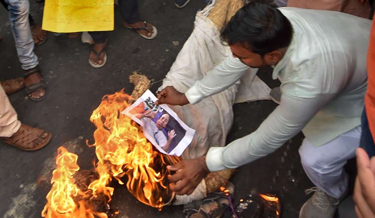 BJP workers burn a photograph of Chief Minister Mamata Banerjee during a protest in Kolkata against alleged failure of law and order situation in West Bengal | PTI