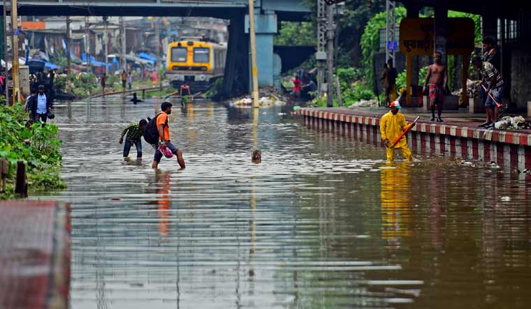 A commuter crosses waterlogged railway tracks in Mumbai | Vishnu V. Nair