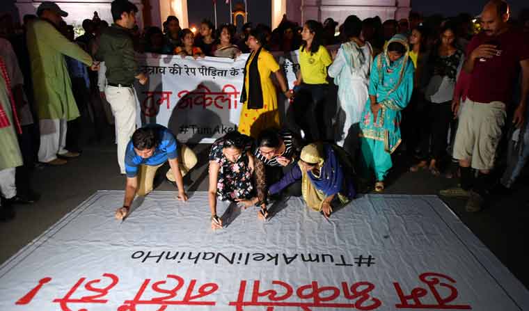 People signing on a banner in support of Unnao rape victim during a peaceful protest at India Gate in New Delhi | Arvind Jain