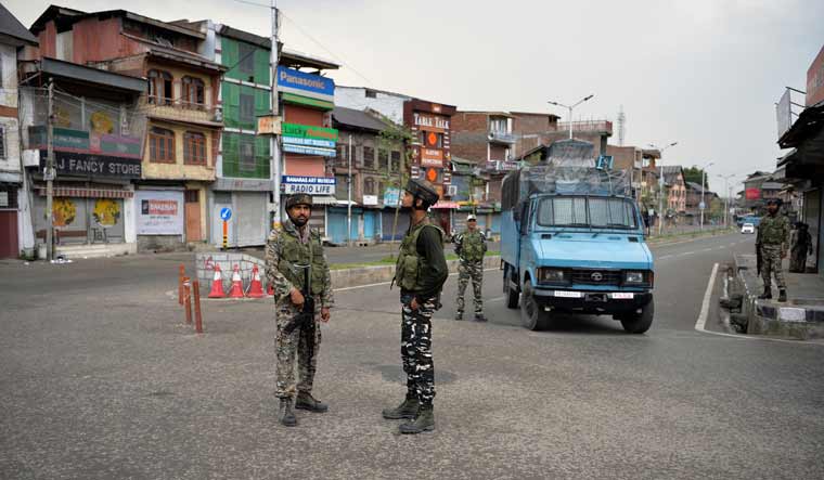 Security personnel stand guard on a street in downtown Srinagar | AFP
