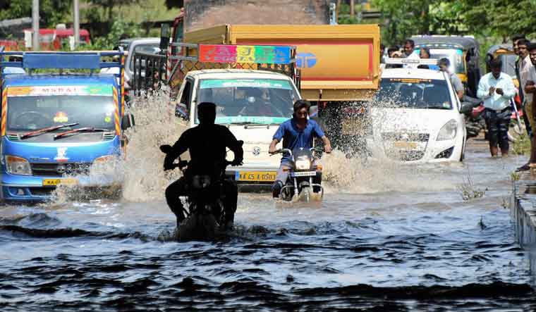 Commuters move through a flooded road near Srirangapatna in Mandya district, Karnataka | AP