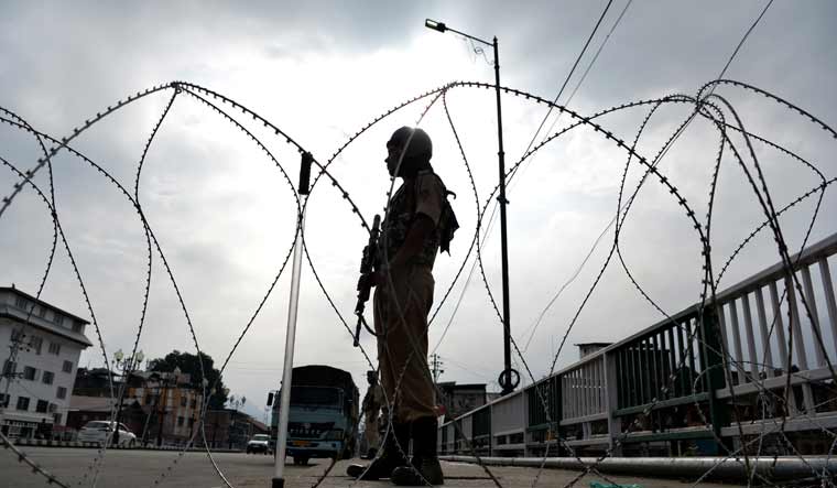 A security personnel stands guard on a street during a lockdown in Srinagar | AFP