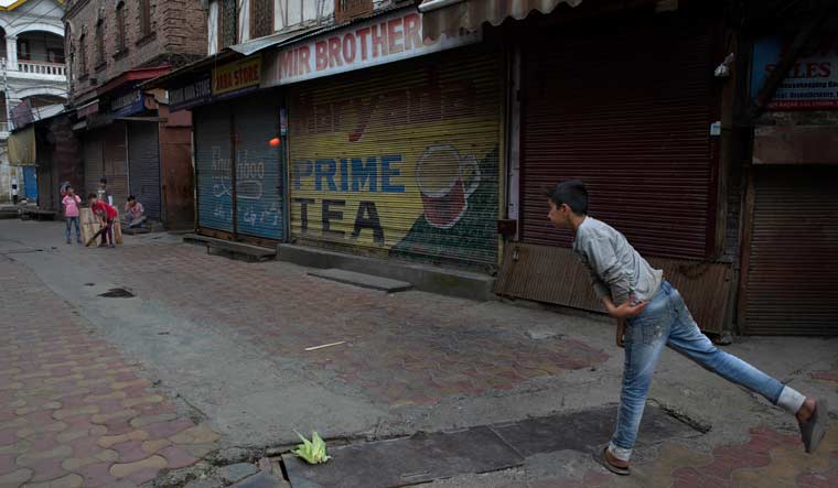 Kashmiri children play cricket outside a closed market in central Srinagar | AP