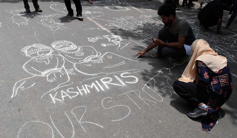 Communist Party of India (CPI) activists draw graffiti on the ground during a protest in New Delhi on August 7 | AFP