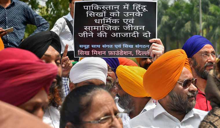 Members of Sikh community display a placard during a protest against alleged forceful conversion of minorities in Pakistan, near Pakistan High Commission in New Delhi | PTI