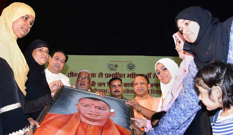 Uttar Pradesh Chief Minister Yogi Adityanath is presented a painting by the victims of triple talaq, at Indira Gandhi Pratishthan, in Lucknow | PTI