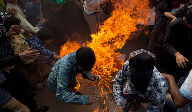 Kashmiris run from flames rising from an Indian flag set on fire