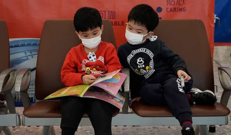 Children wear masks to prevent an outbreak of a new coronavirus in the high speed train station, in Hong Kong | AP