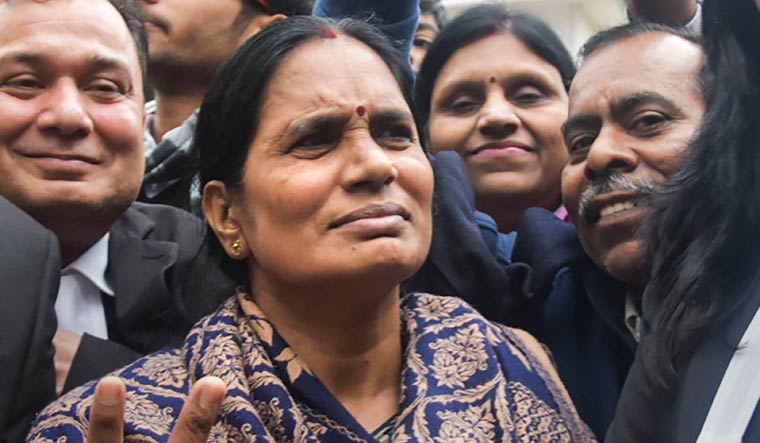 Nirbhaya's mother flashes the victory sign along with lawyers after a court issued death warrants against the four convicts in the case | PTI