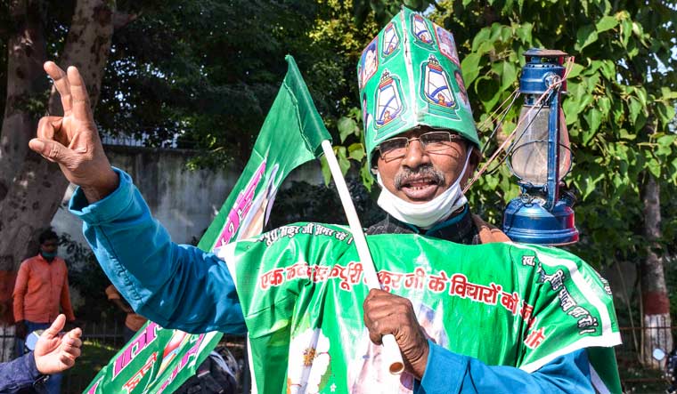 An supporter flashes victory sign during counting of votes for the Bihar Assembly polls, in Patna | PTI