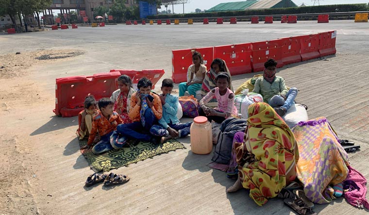 Stranded people wait for transport at toll plaza of Ahmedabad-Vadodara expressway after authorities imposed 60 hours curfew due to a rise in COVID-19 cases in Ahmedabad, Saturday | PTI