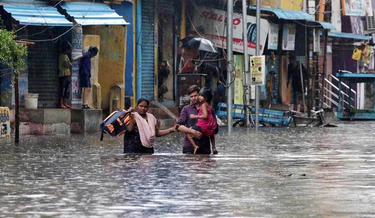 A family wades through a flooded street in Chennai | AP