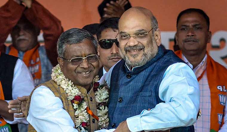 Former Jharkhand chief minister Babulal Marandi (L) greets Union Minister Amit Shah during the merger of Jharkhand Vikas Morcha with the Bharatiya Janata Party (BJP), at an event, in Ranchi | PTI