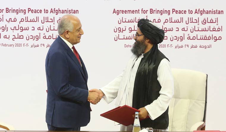 US peace envoy Zalmay Khalilzad, left, and Mullah Abdul Ghani Baradar, the Taliban group's top political leader, shake hands after signing a peace agreement in Doha, Qatar | AP