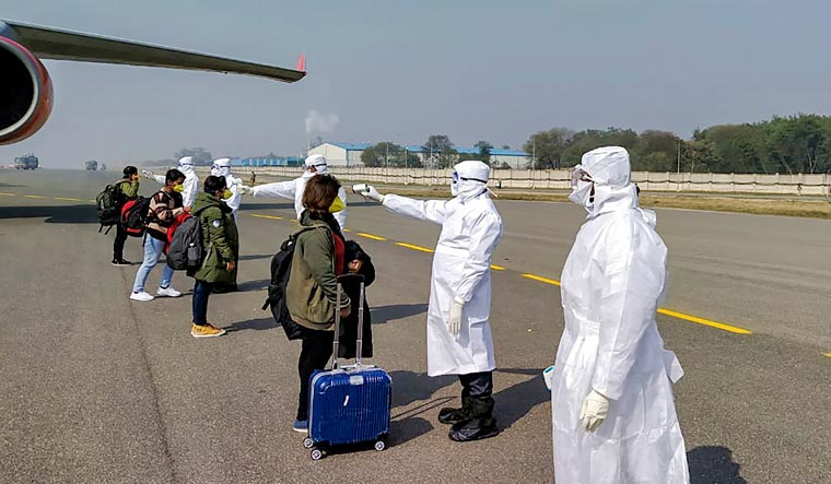 Medics screen Indian nationals after they were brought by an Air India aircraft from China's coronavirus-hit city of Wuhan, at the airport in New Delhi | PTI