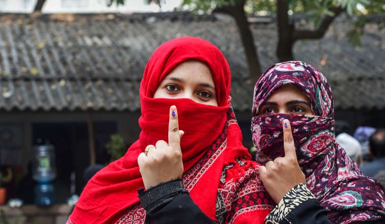 Voters show their inked fingers after casting votes during the Delhi Assembly election at a polling station in Shaheen Bagh | PTI