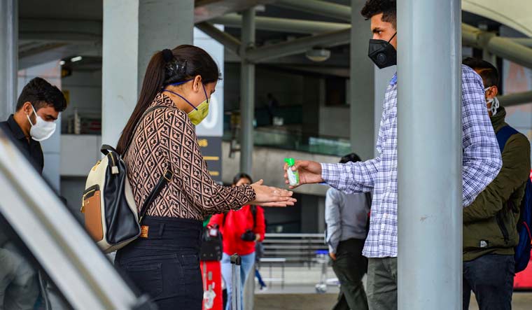 A woman being handed hand sanitiser at Delhi Airport | PTI
