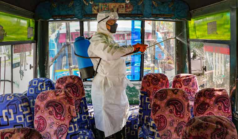 Jammu Municipal Corporation official sprays disinfectant inside a bus to mitigate the coronavirus pandemic | PTI