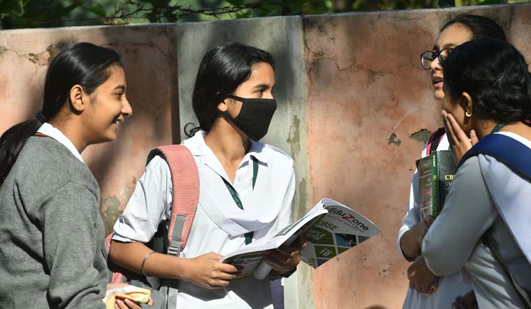 Students wear masks amid coronavirus fears, as they wait outside Kerala School ahead for their Class 10 exams, in New Delhi | PTI