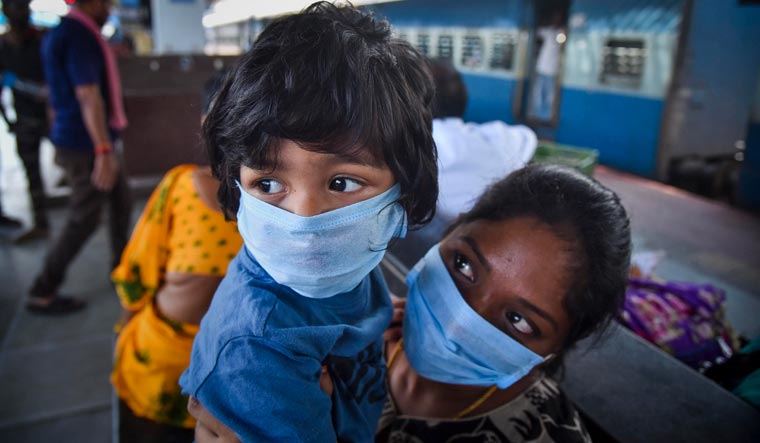 Passengers wear protective face masks in wake of novel coronavirus pandemic at a railway station, in Vijayawada | PTI