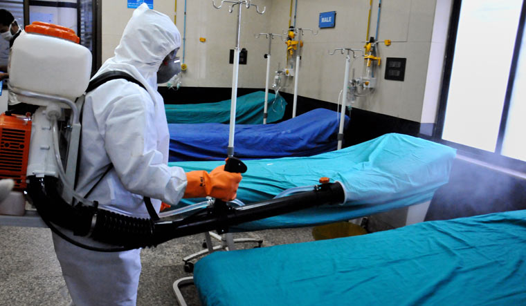 A health worker sprays disinfectants on a hospital bed in the wake of coronavirus pandemic, in Kolkata | PTI
