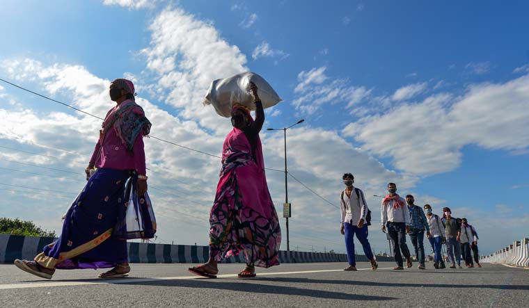 Migrant workers along with their family members walk to their villages, due to no means of transport, during the nationwide lockdown amid coronavirus outbreak, near Anand Vihar railway station in New Delhi | PTI