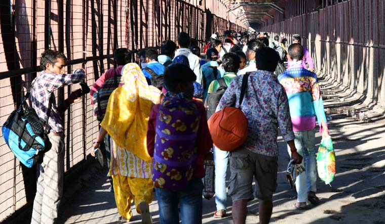 Hundreds of migrant workers, along with their families, are crossing the historic Iron Bridge over the Yamuna as they leave for their villages in Uttar Pradesh | Sanjay Ahlawat