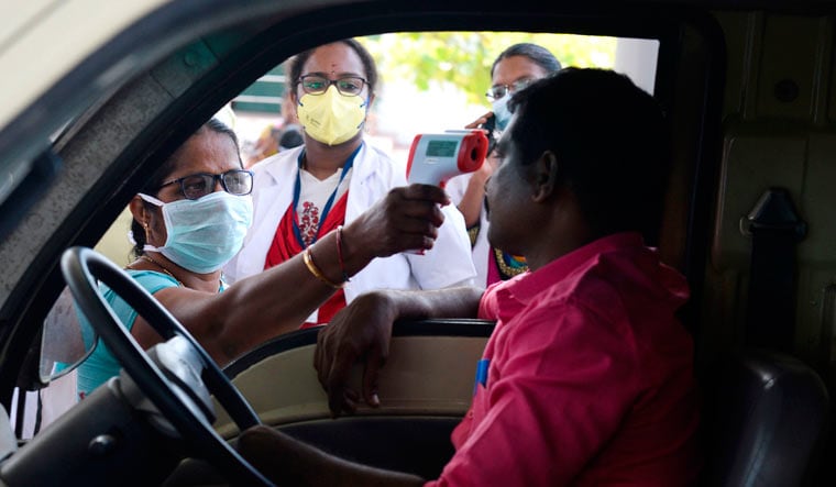 Health officials check the body temperature of a driver at the Tamil Nadu-Andhra Pradesh interstate border, on outskirts of Chennai | AFP