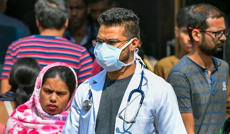 A medic wearing a protective mask in the wake of novel coronavirus or COVID-19 outbreak, walks out of RML Hospital in New Delhi | PTI