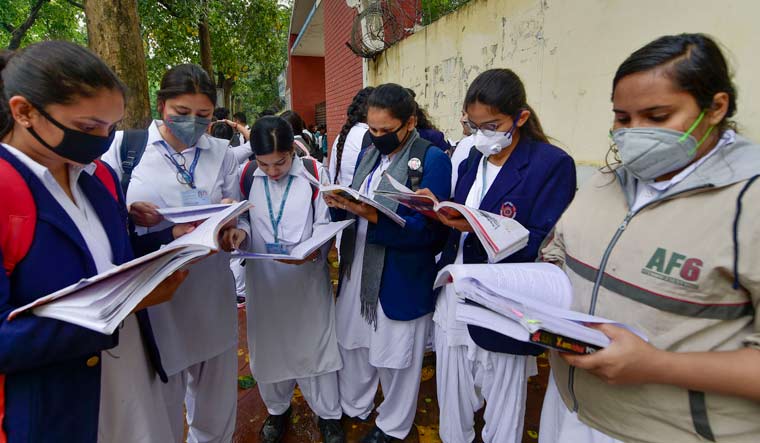 Students wear masks amid coronavirus fears, as they wait outside Kerala School ahead for their CBSE Class 12 exams, in New Delhi | PTI