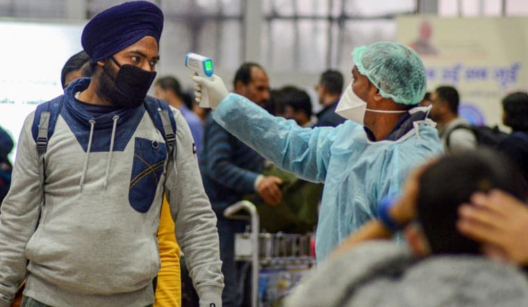  A medic uses a thermal-screening device on a passenger in the wake of the coronavirus outbreak, at an airport in Dibrugarh, Assam | PTI