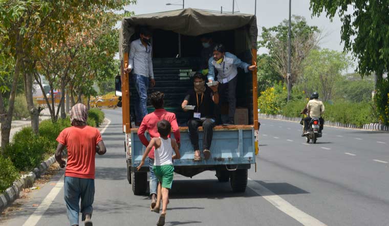 A child runs behind a truck distributing food in Delhi | Arvind Jain