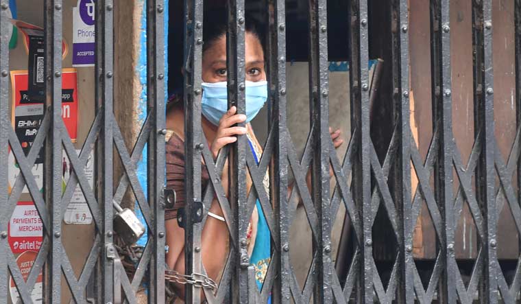 A woman looks out of her house during COVID-19 lockdown, in Kolkata | Salil Bera