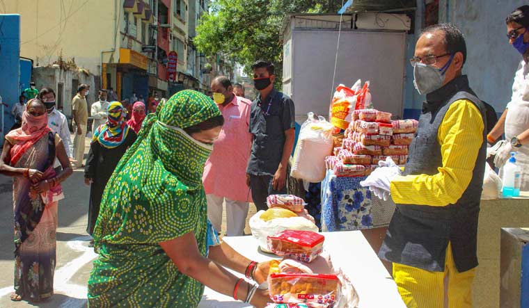 Madhya Pradesh Chief Minister Shivraj Singh Chouhan distributes food packets among poor people during a nationwide lockdown in the wake of coronavirus pandemeic, in Bhopal on March 30 | PTI