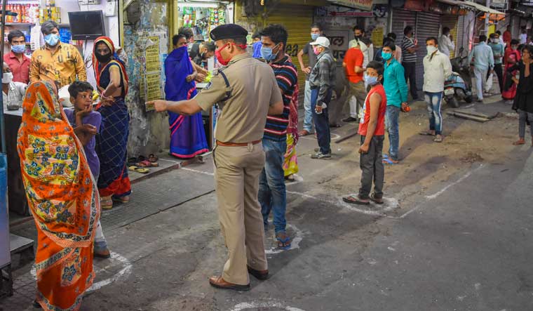  People stand in a queue at safe distance to buy grocery items from a shop in Bhopal | PTI
