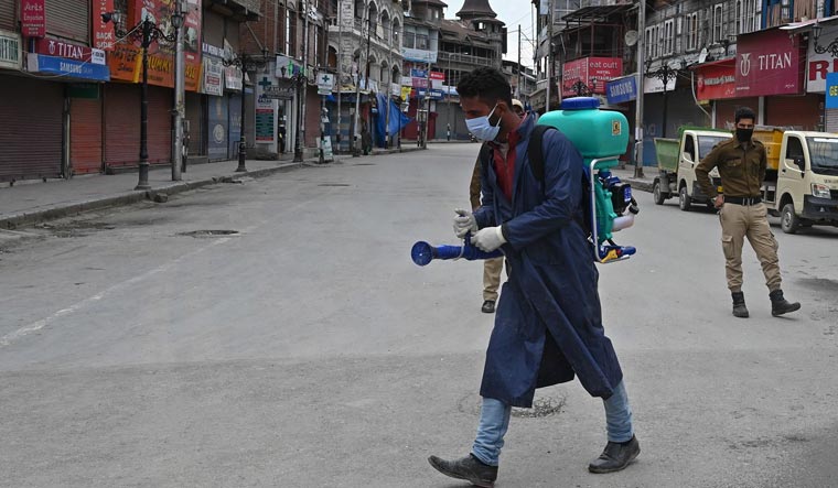 A municipal worker sprays disinfectant during a government-imposed nationwide lockdown in Srinagar | AFP
