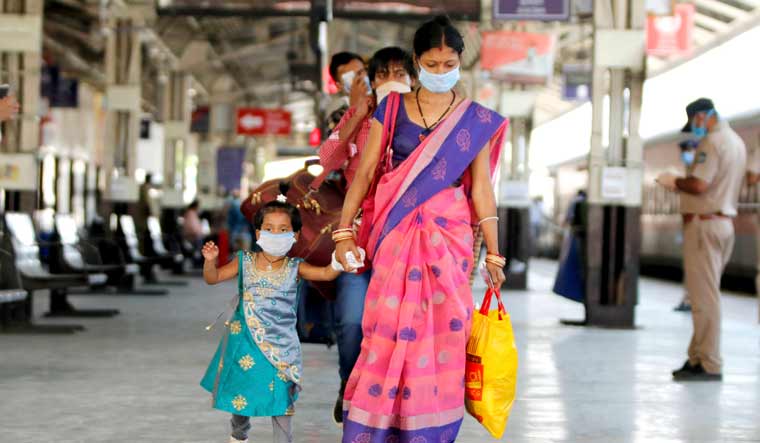 Migrants, stranded in different parts of Gujarat, arrive to board a special train to Odisha at a railway station in Ahmedabad | PTI