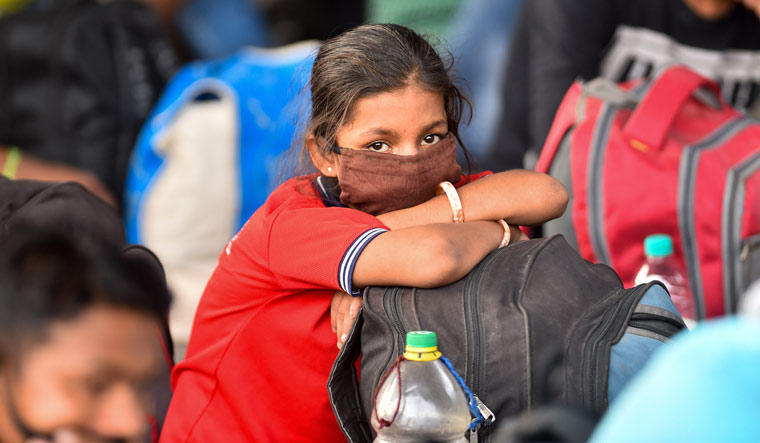 A migrant, wearing a mask, waits to board Shramik special train to Bihar, during the ongoing nationwide COVID-19 lockdown, at Central Railway Station, in Chennai | PTI