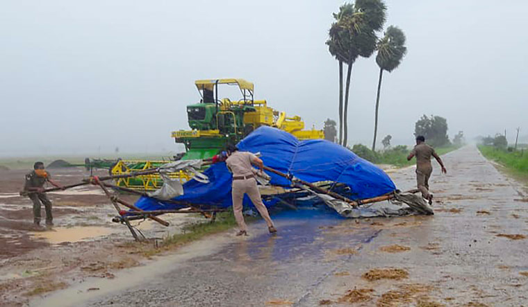 Policemen remove a damaged structure from a road during gusty winds as super cyclone Amphan makes its landfall, at Rasgovindpur in Mayurbhanj district of Odisha | PTI