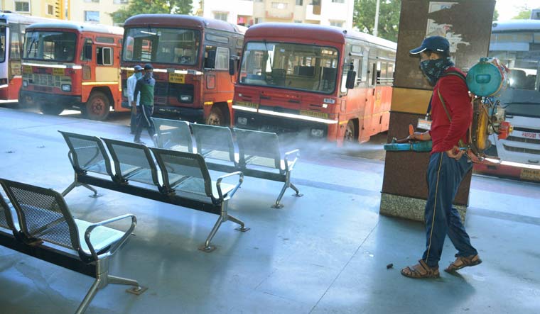 An MCD worker sprays disinfectant at a bus stand in Karad | PTI